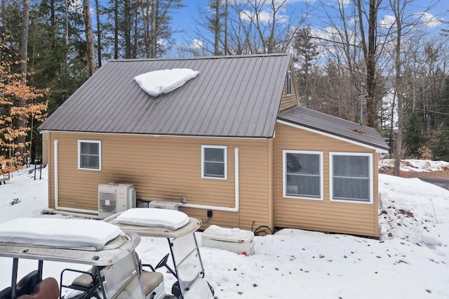 snow covered back of property with metal roof