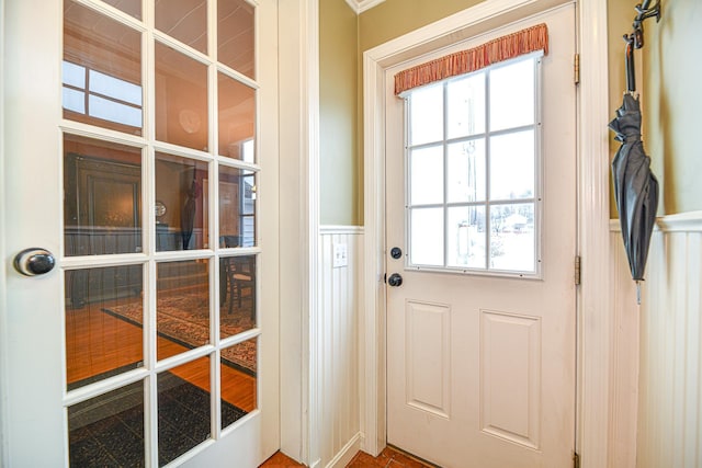 doorway featuring wainscoting