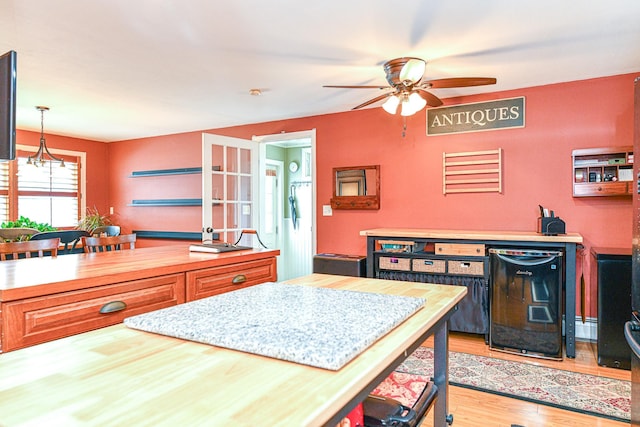 kitchen with wooden counters, refrigerator, ceiling fan, hanging light fixtures, and light wood-type flooring