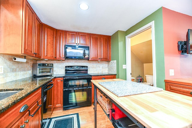 kitchen with a toaster, butcher block countertops, decorative backsplash, black appliances, and light wood-type flooring