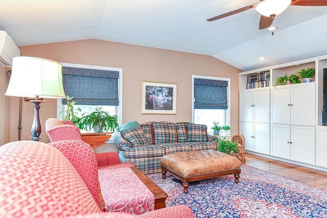 living room with light wood-type flooring, lofted ceiling, an AC wall unit, and a ceiling fan