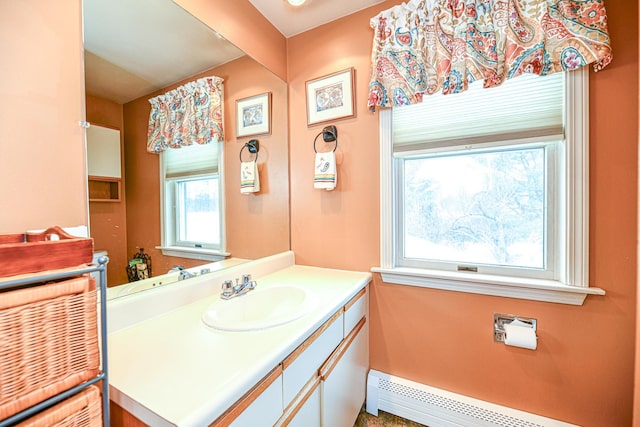 bathroom featuring baseboards, baseboard heating, and vanity