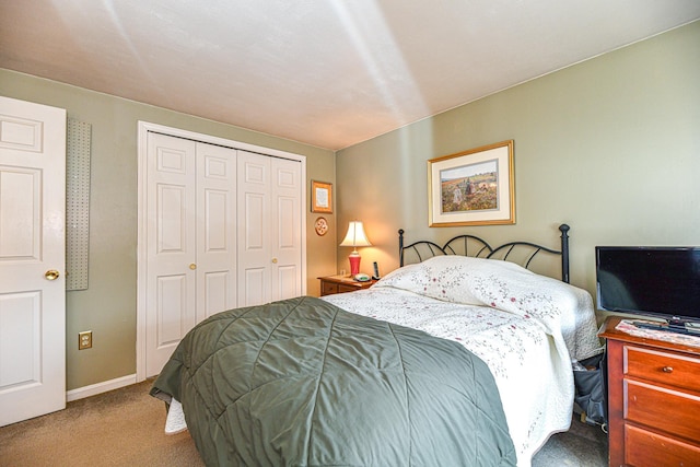 carpeted bedroom featuring baseboards and a closet