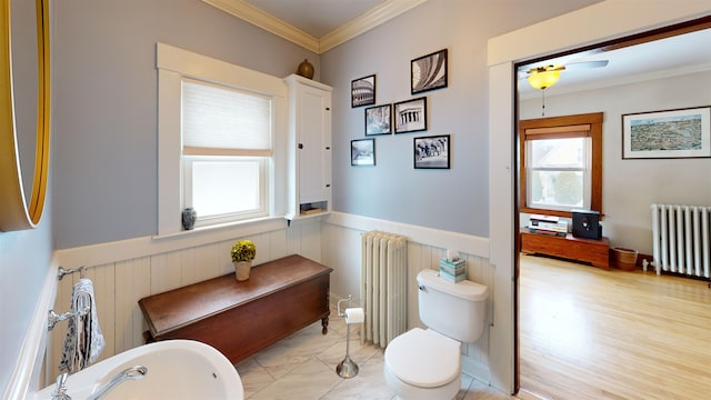 bathroom featuring a soaking tub, wainscoting, radiator heating unit, and ornamental molding