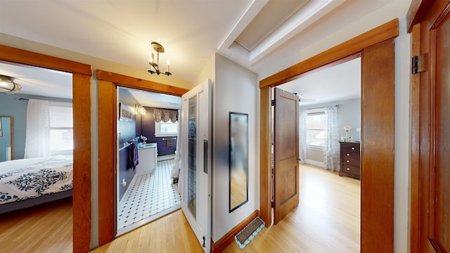 corridor with baseboards and light wood-style floors