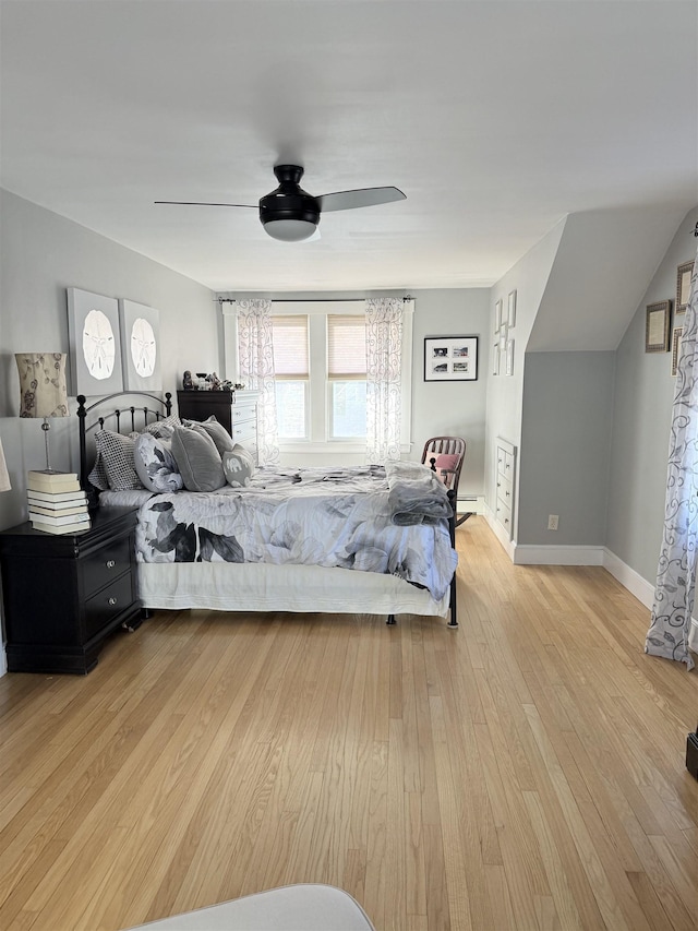 bedroom featuring ceiling fan, baseboards, and light wood-style flooring