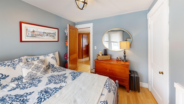 bedroom featuring light wood-style floors and baseboards