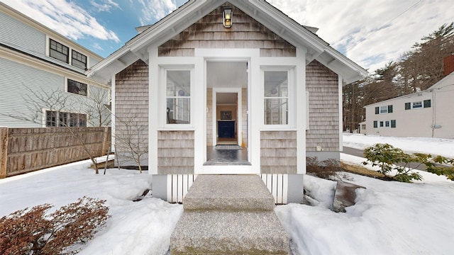 snow covered property entrance featuring fence