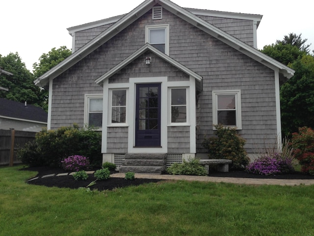 view of front of property with crawl space, entry steps, a front yard, and fence