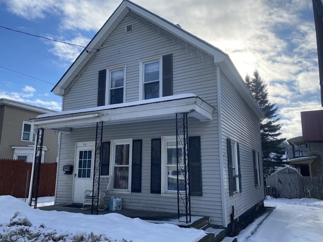 view of front of home with a porch and fence