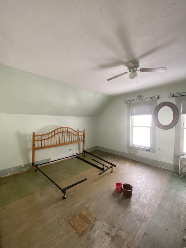 additional living space with baseboards, lofted ceiling, and wood finished floors