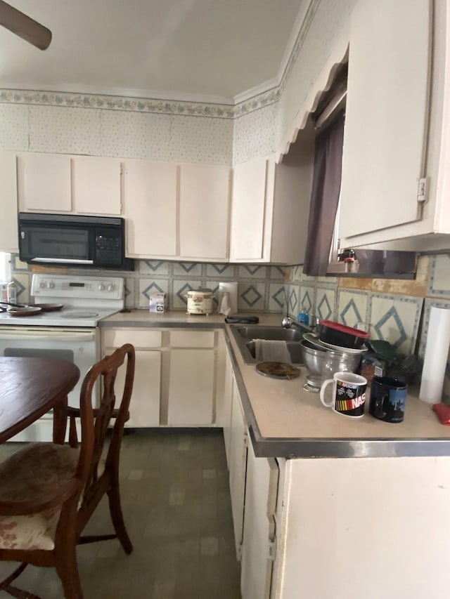 kitchen featuring black microwave, decorative backsplash, white range with electric stovetop, white cabinetry, and a sink