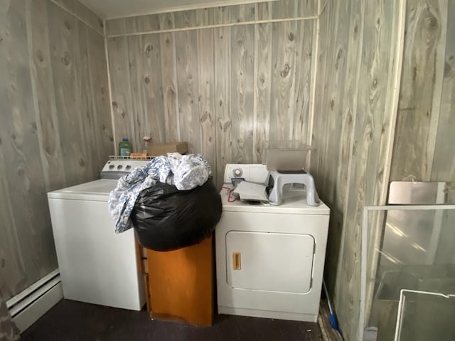 laundry area featuring washer and clothes dryer, wooden walls, laundry area, and a baseboard radiator