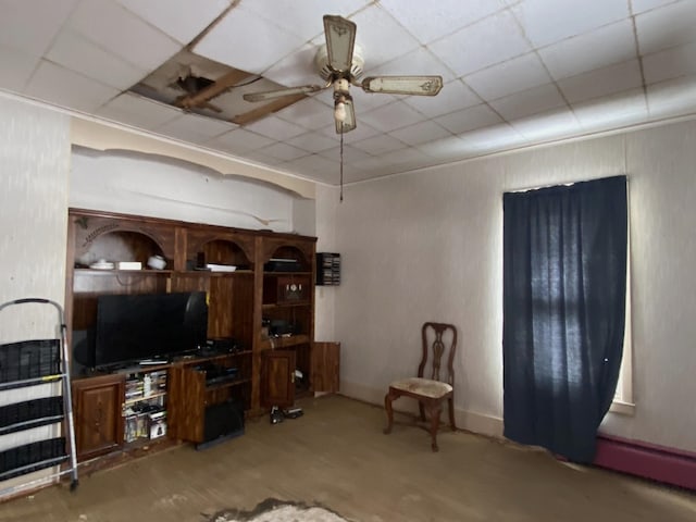 living room featuring a ceiling fan, a paneled ceiling, and baseboards