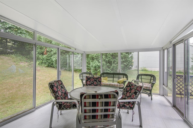 sunroom featuring lofted ceiling and a healthy amount of sunlight