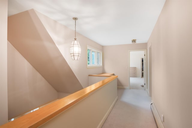 corridor featuring an upstairs landing, light carpet, and baseboards