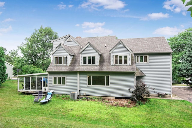 rear view of property with cooling unit, a shingled roof, a yard, and a sunroom