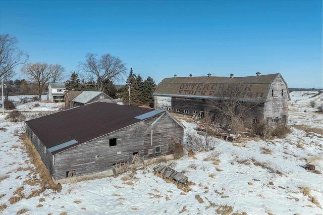 view of snowy exterior featuring an outbuilding and a barn