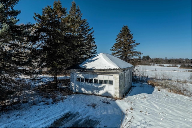 snow covered garage with a detached garage