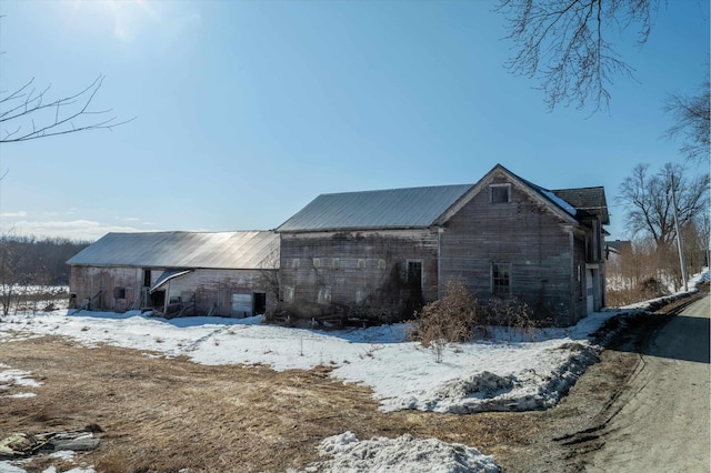 view of snowy exterior with a barn and an outdoor structure