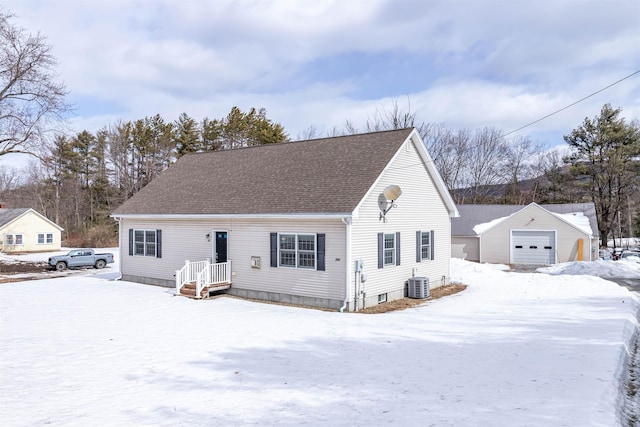 view of front facade featuring an outbuilding, a garage, central AC, and a shingled roof