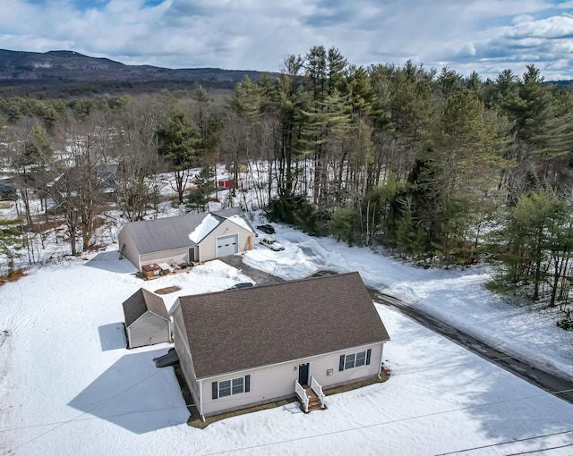 snowy aerial view featuring a forest view