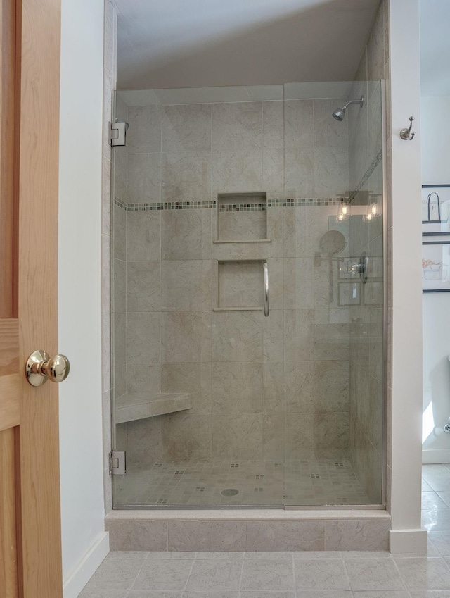 bathroom with tile patterned flooring, a stall shower, and baseboards