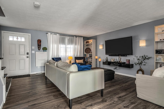 living area with dark wood-style floors, a textured ceiling, and baseboards