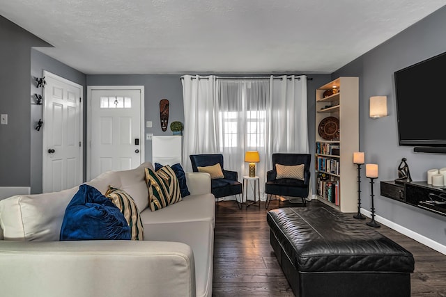 living room with dark wood finished floors, baseboards, and a textured ceiling