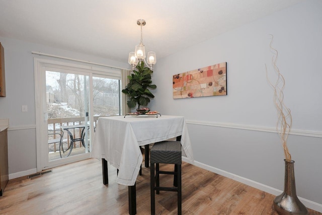 dining space with visible vents, baseboards, and wood finished floors