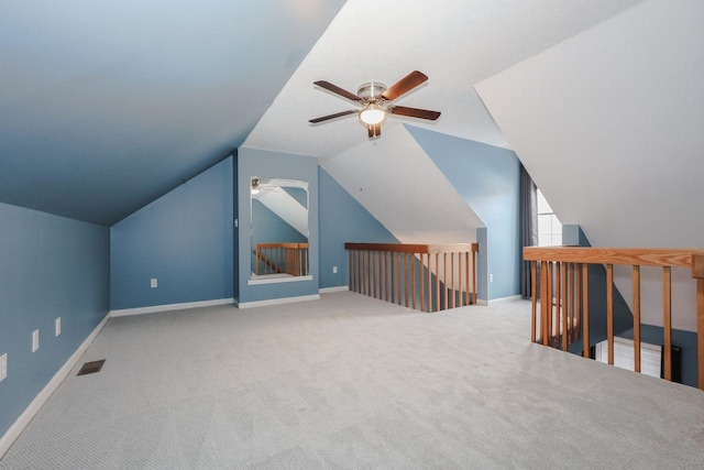 additional living space featuring visible vents, a ceiling fan, carpet flooring, baseboards, and vaulted ceiling