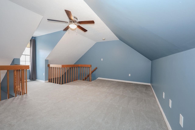 additional living space with baseboards, carpet flooring, and vaulted ceiling