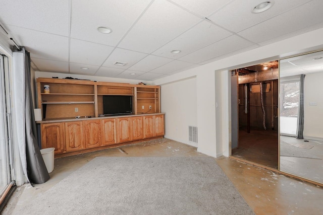 unfurnished living room featuring a drop ceiling, visible vents, and unfinished concrete flooring