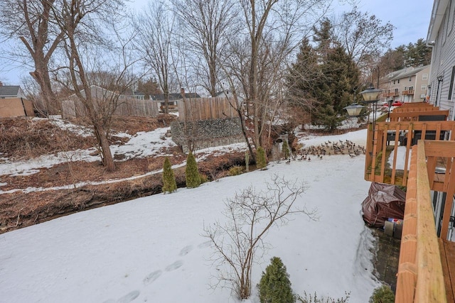 yard covered in snow featuring fence