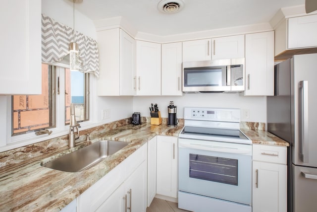 kitchen with a sink, stainless steel appliances, visible vents, and white cabinets