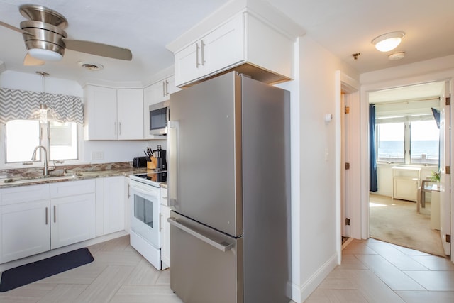 kitchen with light stone countertops, visible vents, a sink, ceiling fan, and stainless steel appliances