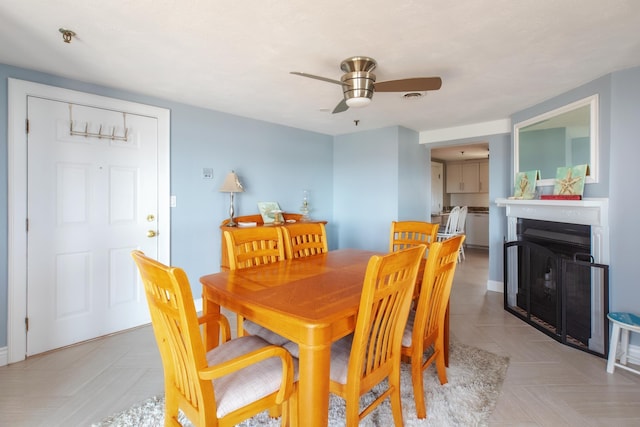 dining area with a fireplace, a ceiling fan, and visible vents