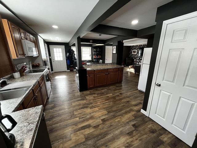 kitchen with white appliances, recessed lighting, dark wood-style floors, and a sink