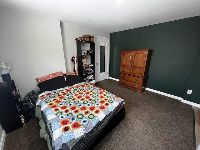 bedroom with baseboards and dark carpet