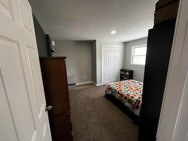 carpeted bedroom with baseboards and a closet