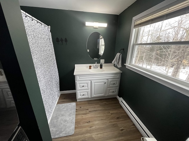 full bathroom featuring vanity, baseboards, and wood finished floors