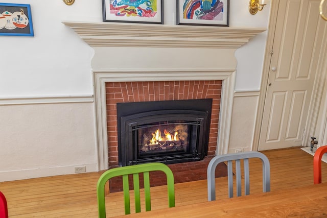 details with a fireplace with flush hearth and wood finished floors