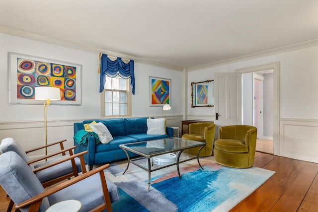 living area featuring wood finished floors, ornamental molding, and wainscoting