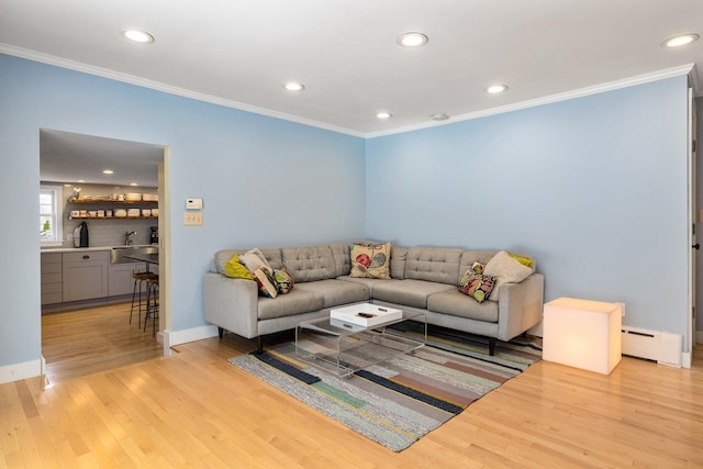 living room featuring light wood finished floors, recessed lighting, crown molding, and a baseboard radiator