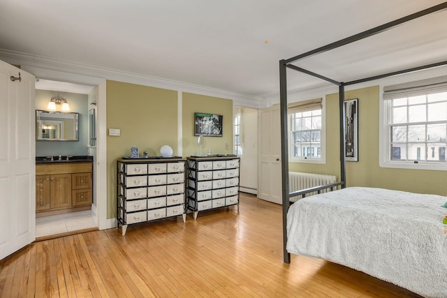 bedroom featuring light wood-type flooring, baseboard heating, ornamental molding, and radiator heating unit