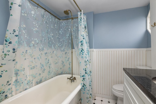 full bathroom featuring vanity, toilet, a bathtub, and a wainscoted wall