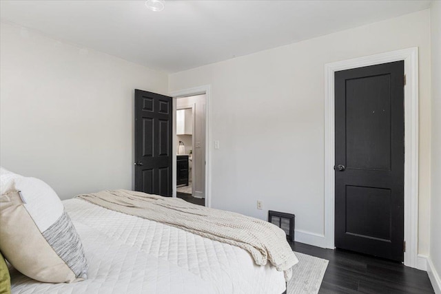 bedroom with baseboards and dark wood-style flooring