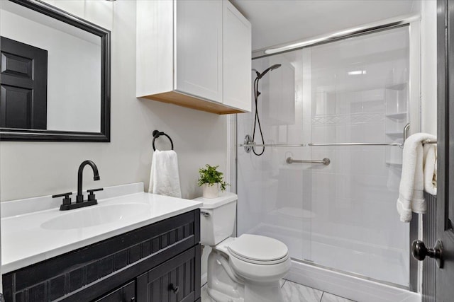 full bath featuring toilet, marble finish floor, a stall shower, and vanity