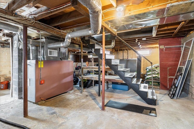 unfinished below grade area featuring heating unit, visible vents, and stairs