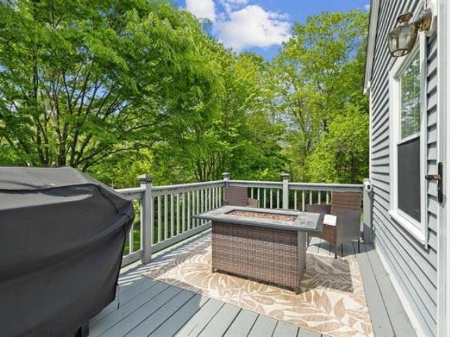 wooden terrace with a fire pit and grilling area